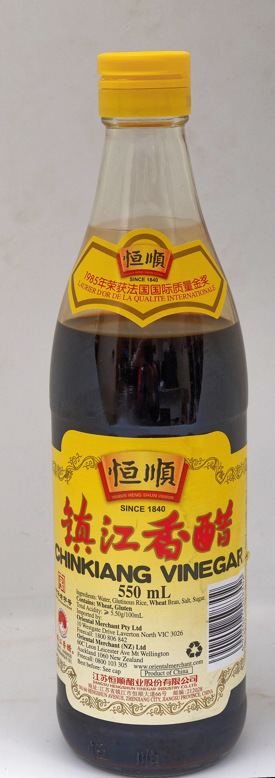 A tall bottle of Chinkiang black vinegar with a yellow label