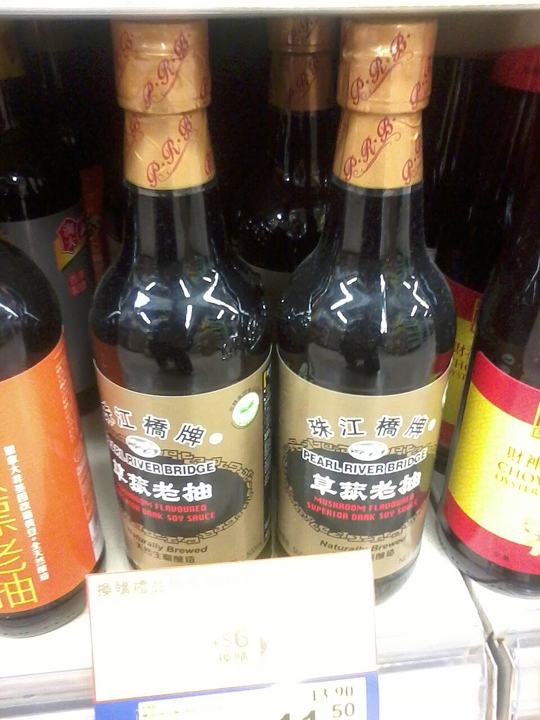 Glass bottles of Pearl River Bridge dark soy sauce on a shop shelf