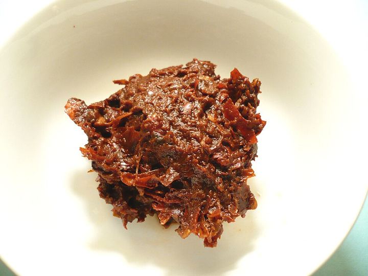 A small plate of Pixian doubanjiang, a dark red-brown paste with visible pieces of bean and chilli
