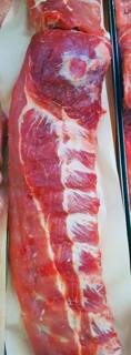 A raw rack of pork spare ribs