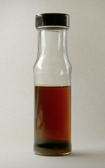 A glass bottle of dark amber toasted sesame oil